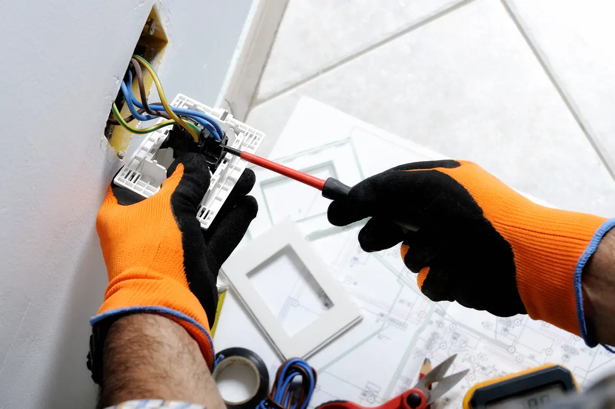 Elektroinstallationen von Navolta AG – Fachkraft montiert eine Steckdose mit Schraubendreher