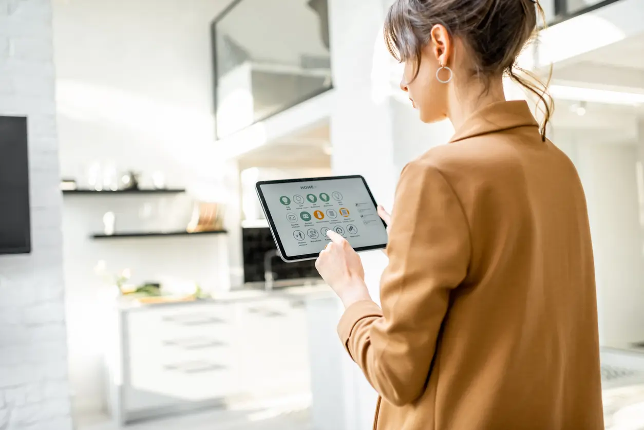 Gebäudeautomation von Navolta AG – Frau steuert Smart-Home-Funktionen über ein Tablet
